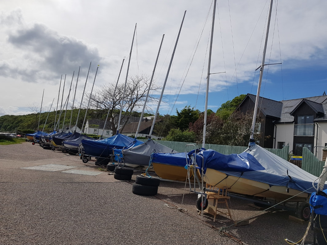 Larger dinghies stored on the tarmac at Chanonry Sailing Club.