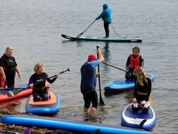 Paddlers getting a SUP lesson at Fortrose