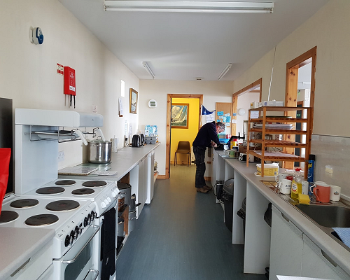 Chanonry Saliling Club galley showing the well equipped kitchen and club member.